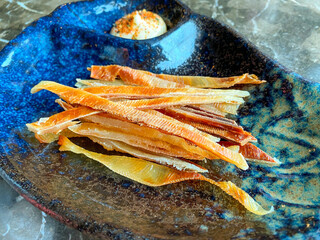 Artfully arranged fish strips served in a blue dish
