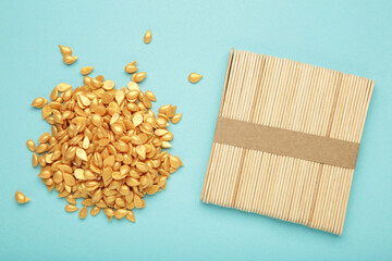 Beautiful gold depilatory wax granules and wooden spatulas on blue background. Epilation,...