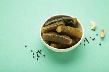 Marinated pickled cucumber with garlic on mint background.