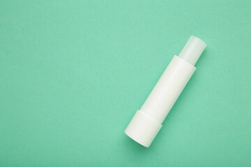 Lip balm on mint background. Space for text