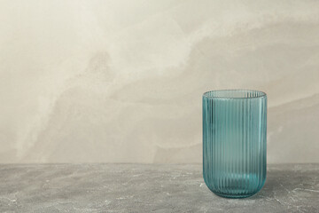 Empty blue glass on grey concrete background.