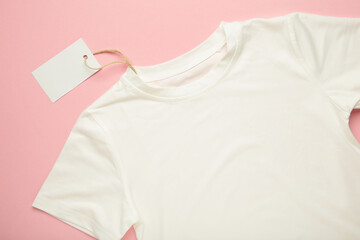 White t-shirt and blank empty label on pink background.