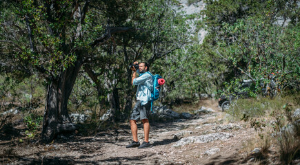 Male photographer with a camera on a hike.