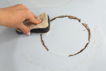 Woman cleaning electronic ceramic stove surface using sponge