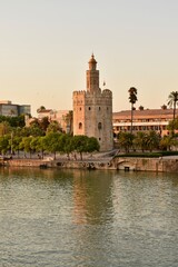Obraz premium Torre del Oro, a historical tower in Seville, Spain, standing by the river. A symbol of the city’s rich past and tourism appeal.