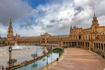 Fototapeta premium View of Plaza de España in Seville, Spain, taken from the South Tower, showing the entire structure including the canal and the North Tower on a partly cloudy day.