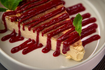 Delicious Layered Dessert with Smooth Cream Base and Rich Berry Sauce Garnish, Perfectly Complemented by Fresh Mint Leaves for a Tasty Delight