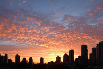 breathtaking summer sunset in urban setting showcasing silhouettes of towering buildings against sky