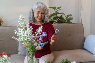 Elderly Woman Arranging Fresh Flowers at Home
