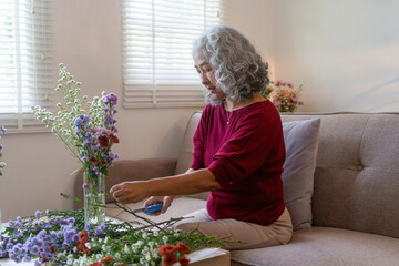 Elderly Woman Arranging Fresh Flowers at Home
