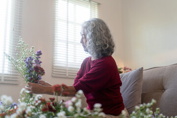 Elderly Woman Arranging Fresh Flowers at Home