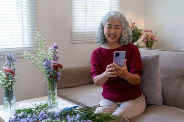 Senior Woman Taking Photo of Her Floral Arrangement