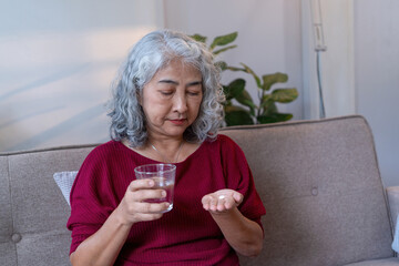 Senior Woman Taking Medication with Water at Home