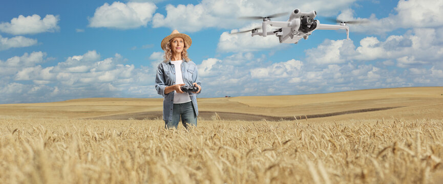 Female farmer flying a drone over a wheat field - Powered by Adobe