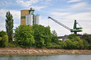 Riverside Industrial Site with Silos and Loading Crane 