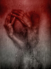 A man behind wet glass, hands pressed against it, expressing emotional pain.