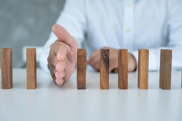 insurance with hands protect domino. Businessman hands stop dominoes falling in business crisis....