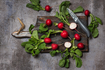Fresh Radishes Cut In Half Displayed On A Dark Plate With Greenery