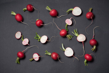 Scattered Fresh Radishes And Slices Artistically Arranged On Dark Surface
