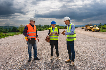 Engineers are discussing and working on a section of highway.	
