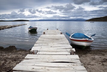 Wooden old pier with boats in the Island of the Sun, located in Lake Titicaca, municipality of...