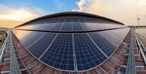 Solar Panel Photovoltaic installation on a Roof of factory, sunny blue sky background, alternative...