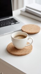 White coffee cup on cork coaster workspace
