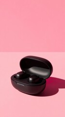Stylish black wireless earbuds case on pink background