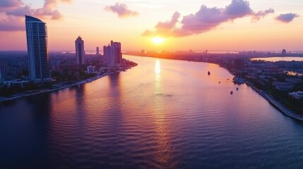 Fototapeta premium Serene Sunset Over City Skyline with Reflections on Water