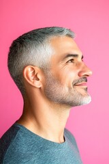 Fototapeta premium Creative of style for aging men. Fashionable men's disconnected undercut haircut - midlife arabian man with short hair. Pink solid background. A studio glamour portrait of a confident man.