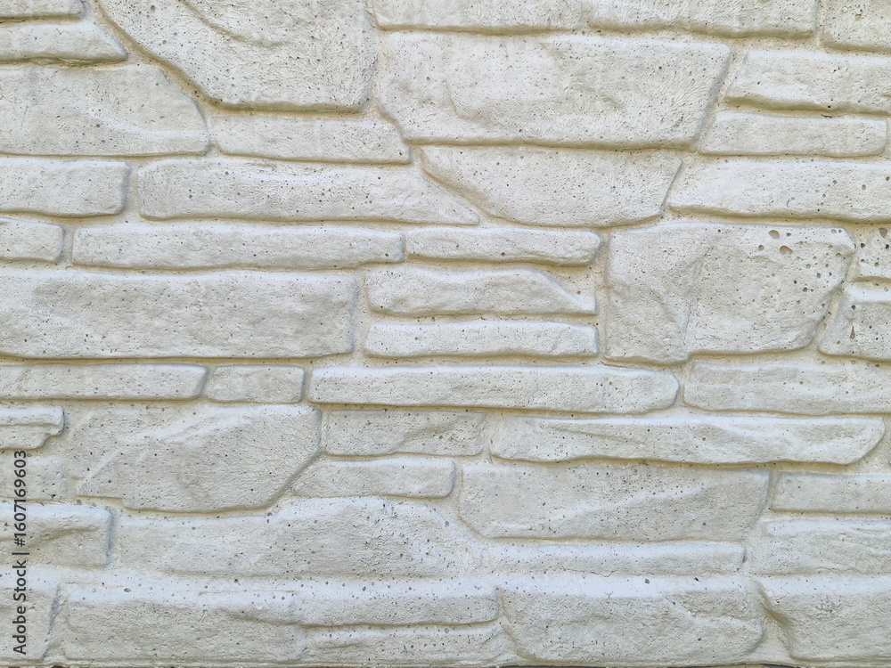 Poster close-up view of a textured white stone wall, featuring various shapes and sizes. the surface create