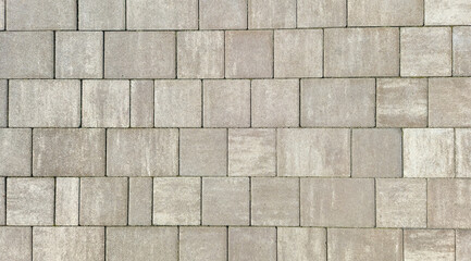 Close-up view of a textured pavement made of gray concrete blocks, showcasing a pattern that can be used in construction, landscaping, and architectural design.