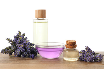 Natural essential oil and lavender flowers on wooden table against white background