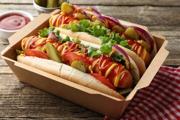 Tasty hot dogs served on wooden table, closeup