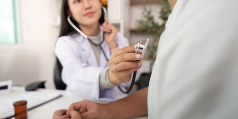 Obraz premium Healthcare Consultation. Doctor using stethoscope for patient checkup in modern clinic.