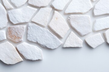flat lay of broken ceramic shards forming abstract irregular pattern clean off-white surface as backdrop