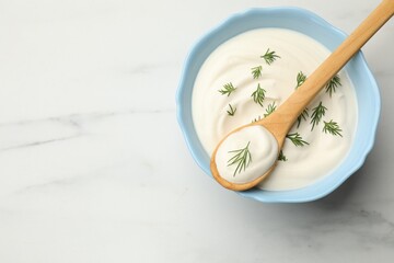 Tasty sour cream with dill on white table, top view. Space for text