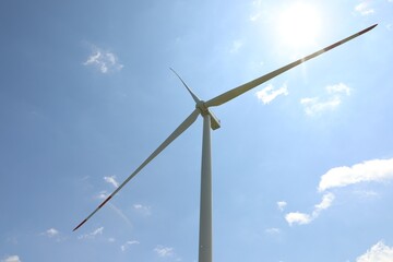 Modern wind turbine against blue sky, low angle view