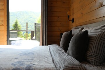 Comfortable bed near window in hotel room
