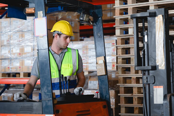Warehouse worker operating forklift in industrial storage facility, focusing on control levers with...