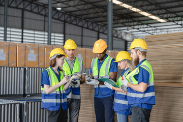 Multiracial warehouse team discussing inventory and logistics strategy during morning briefing with digital tablets and checklists.