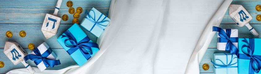 Hanukkah background. Dreidel, with blue lettering נ‎ nun, ג‎ gimel, ה‎ hei, ש‎ shin,...