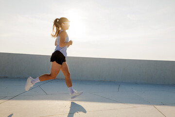 Joyful runner embracing morning freedom on a rooftop