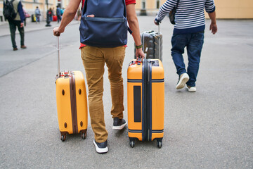 Tourists walking with luggage toward city