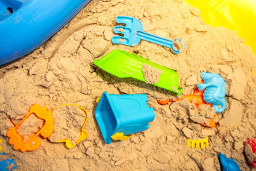 Sandbox outdoor. Children's wooden sandbox with various toys for the game. Summer concept....