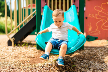baby playing on outdoor playground. Kids play on school or kindergarten yard.