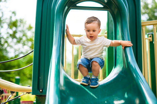 baby playing on outdoor playground. Kids play on school or kindergarten yard.