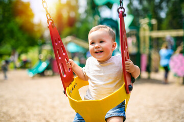 Child girl playing on outdoor playground. Kid play on school or kindergarten yard