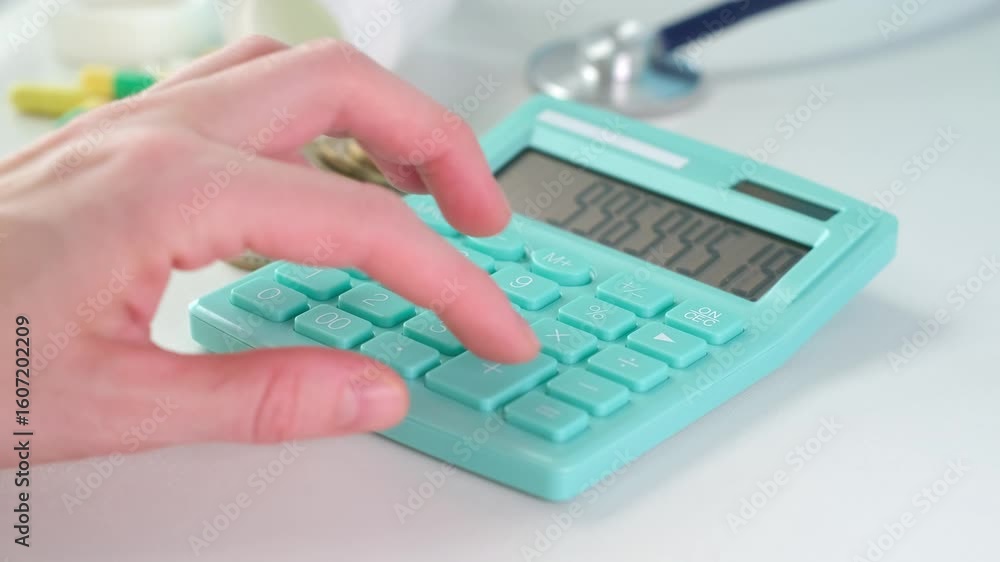 Poster a person is using a calculator to add up the numbers. the calculator is green and has a white backgr