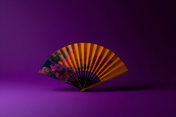 Elegant red and navy fan adorned with floral patterns displayed on a vibrant purple background showcasing traditional craftsmanship